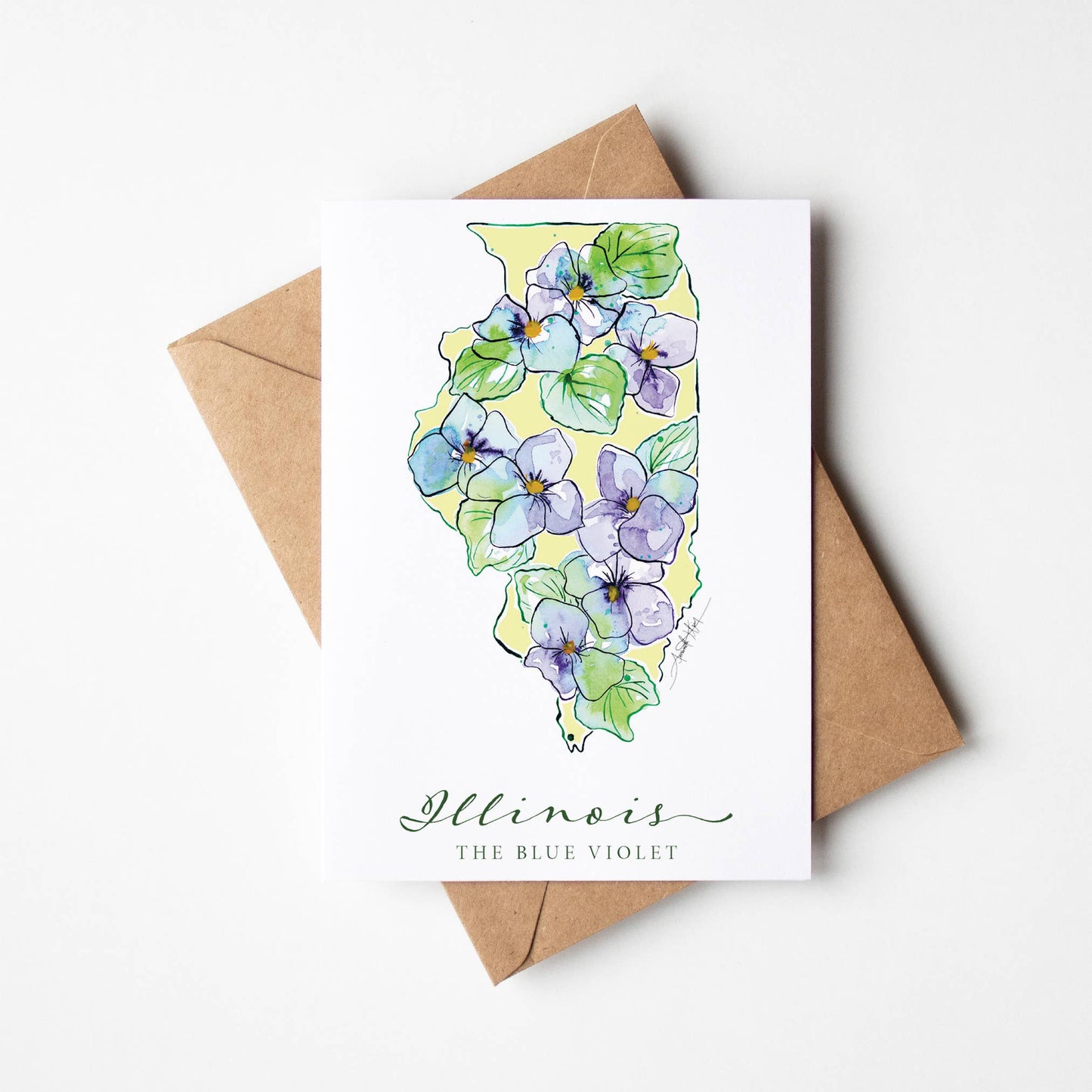 Card with Illinois shape on it with a blue violets design on a white background with a brown envelope.