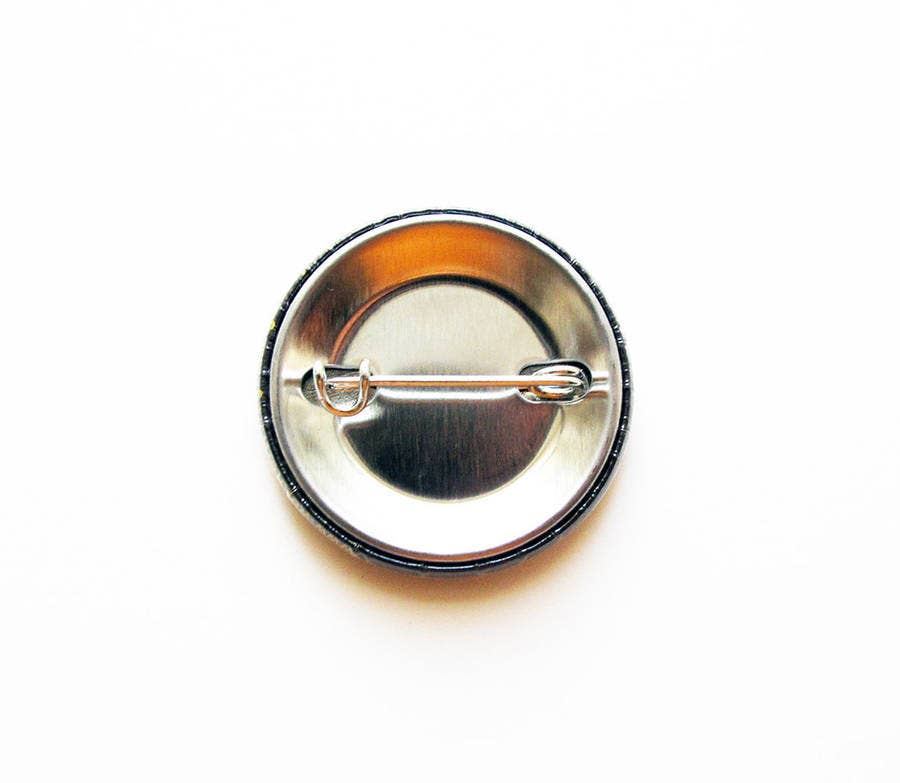 Back of button with metal pin on white background.
