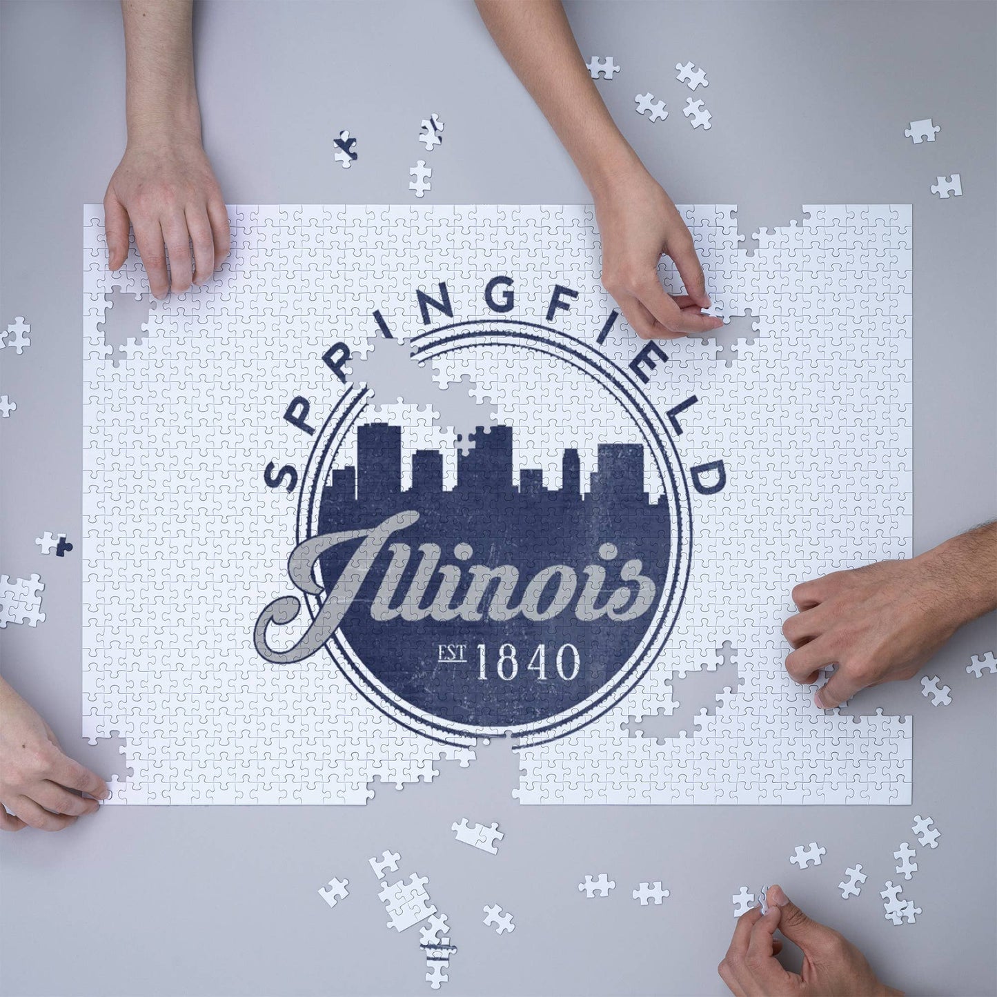 Photo of models putting together the “Springfield, IL Seal” 1000 Piece Illinois Puzzle.