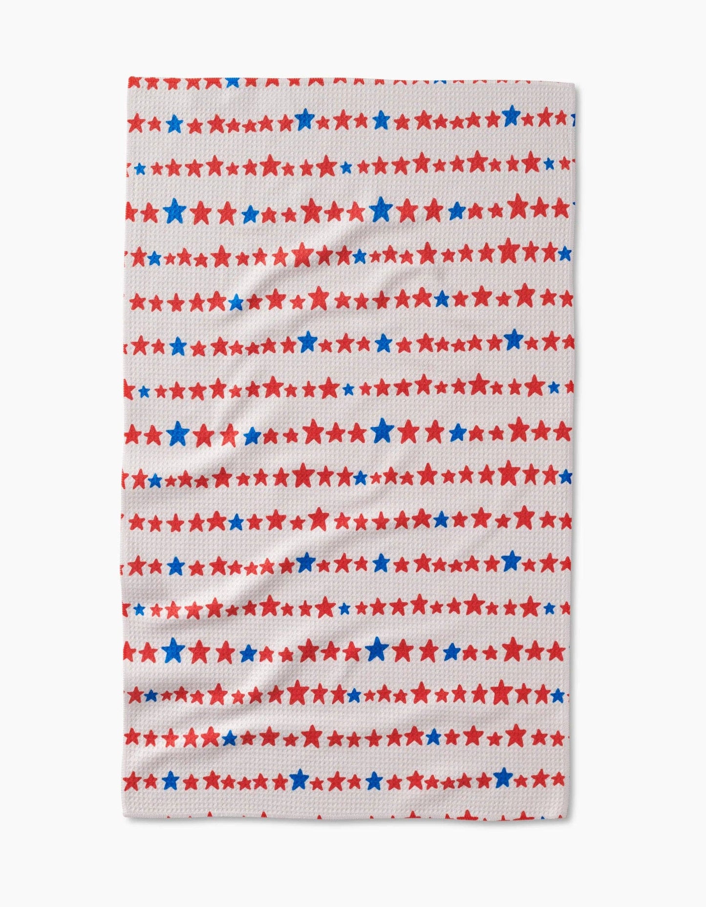 Decorative white tea towel with blue and red stars arranged in a stripe like pattern on a white background. 
