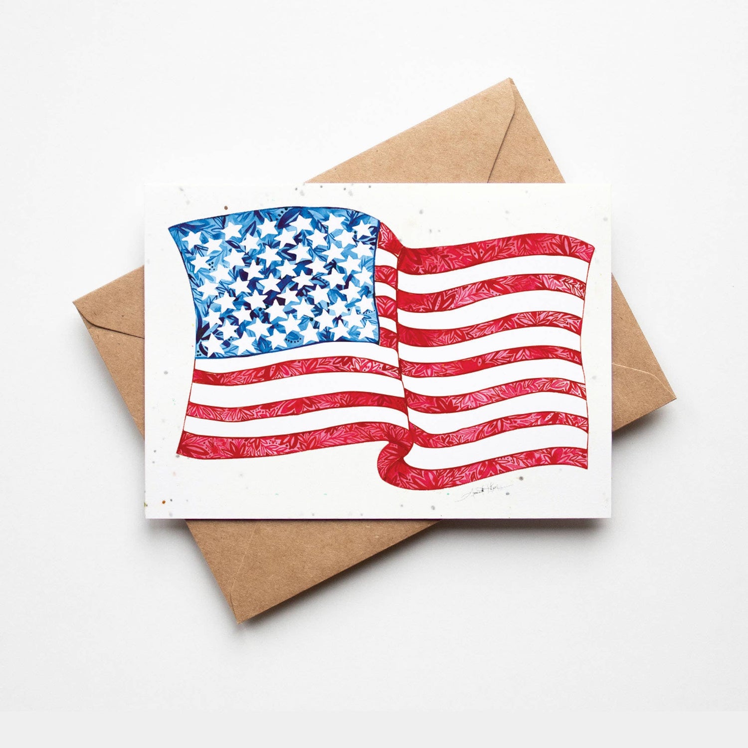 Card with American flag design on a white background with a brown envelope.