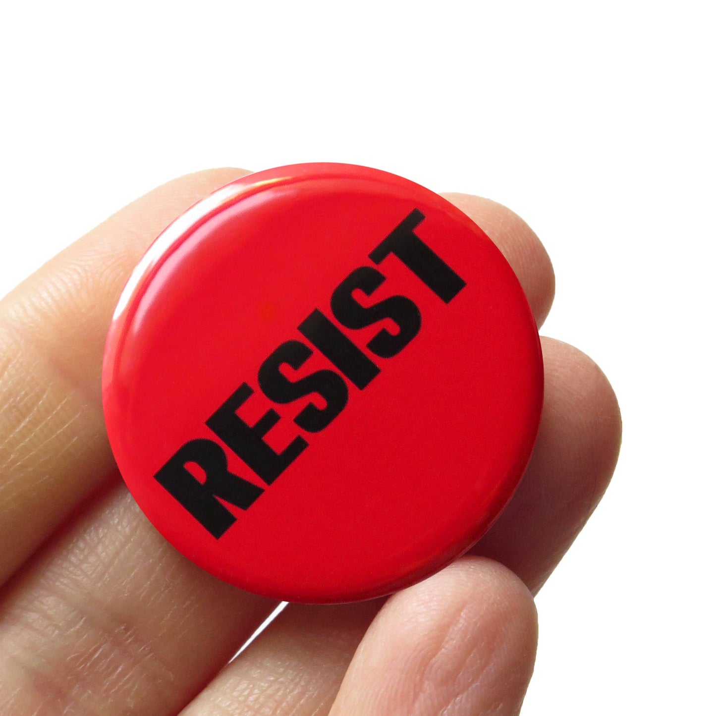 Red button with 'RESIST' text held in a hand against a white background