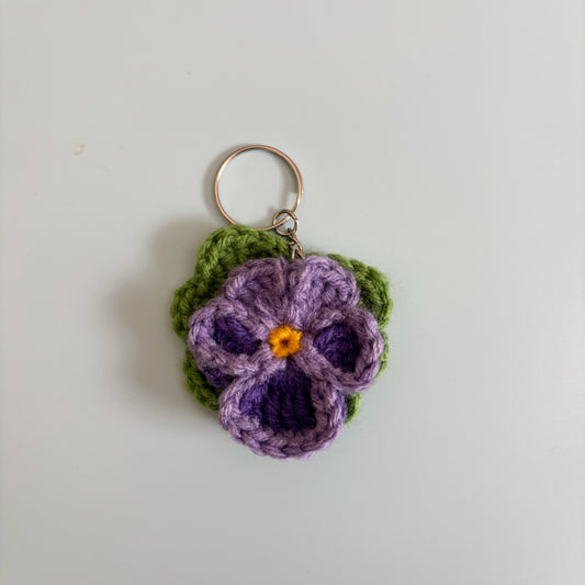 Crocheted violet flower keychain on a white background