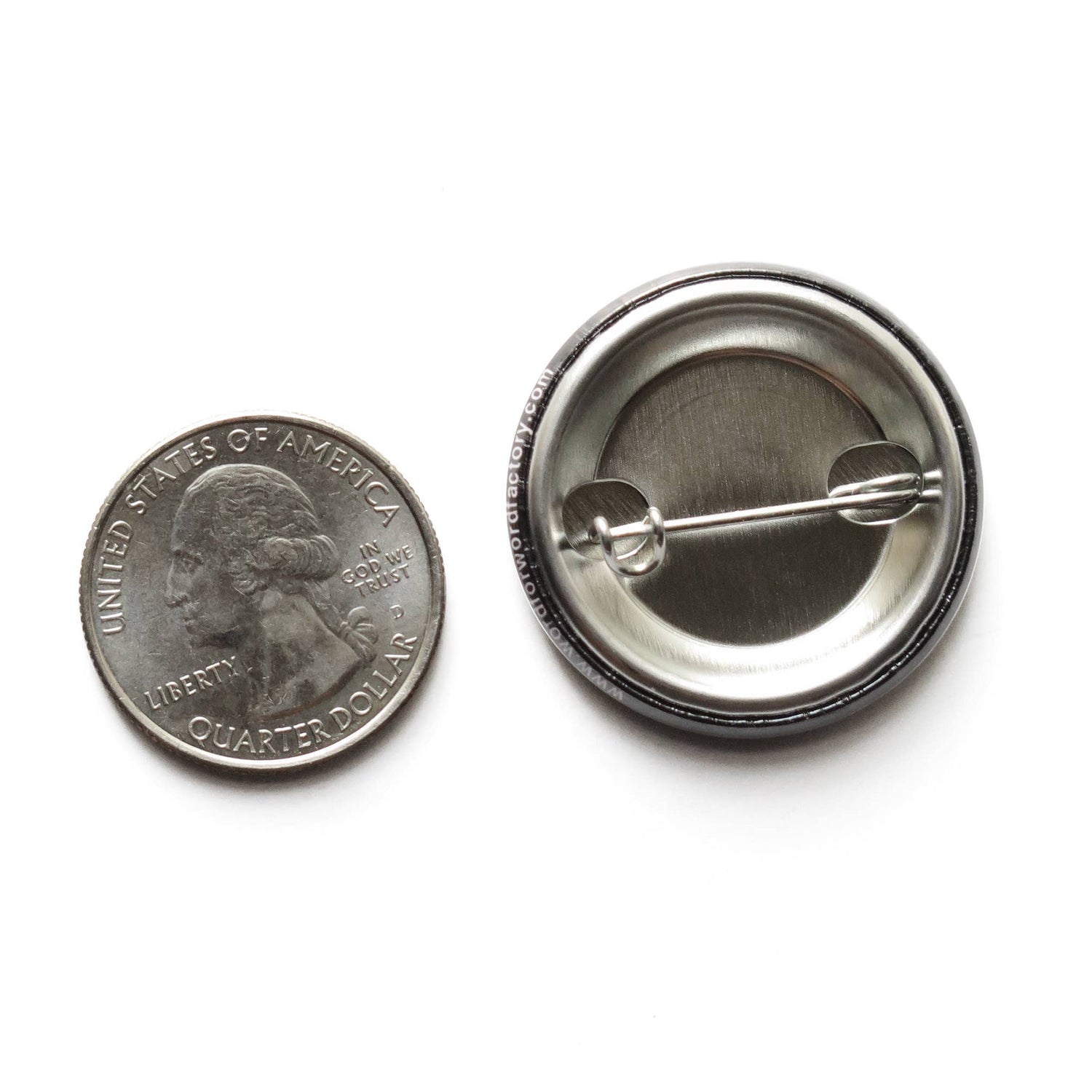 US quarter coin next to the back of a button with a metal pin showing size comparison on a white background.