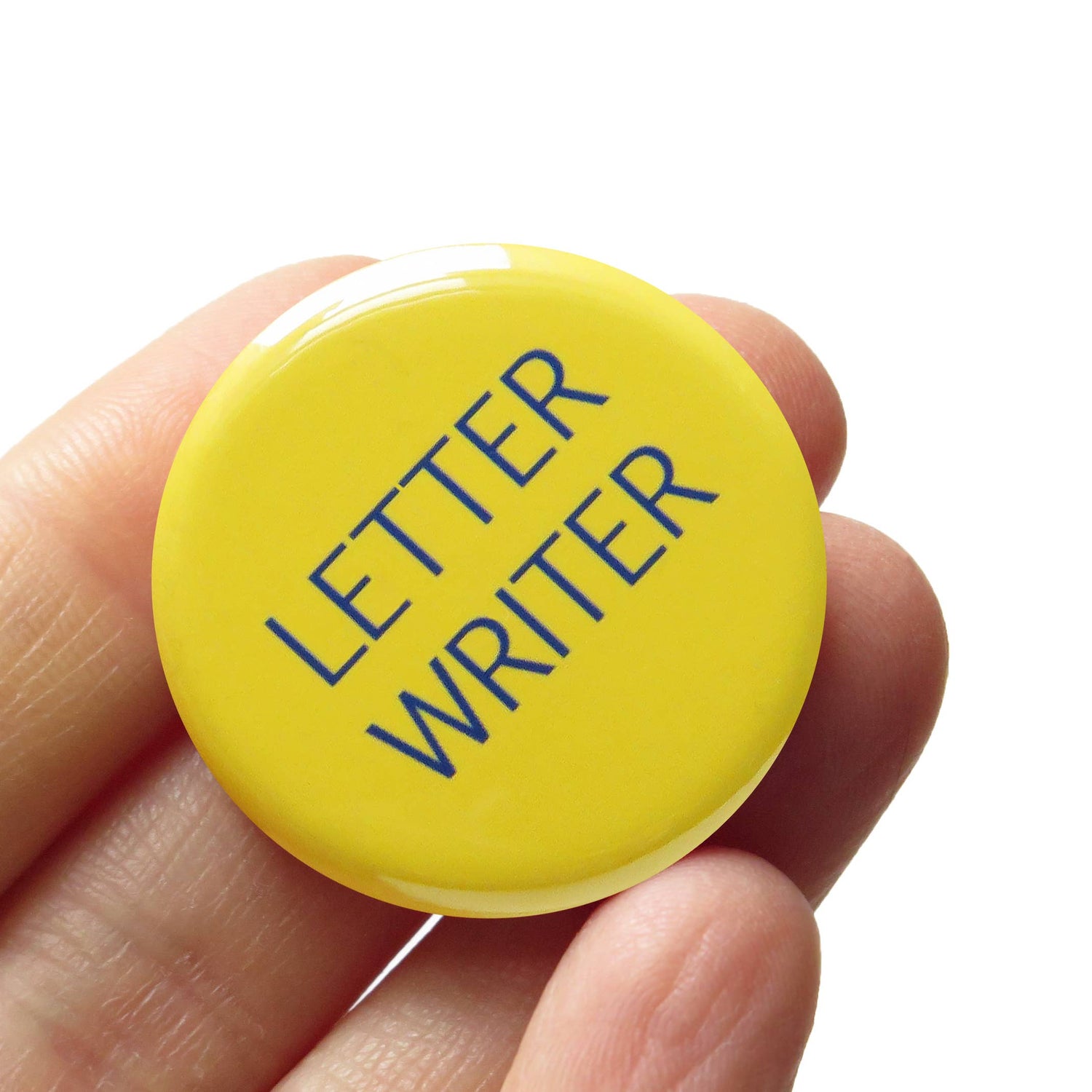 Yellow button with 'Letter Writer' text held in a hand against a white background