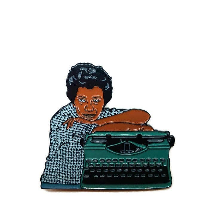 Enamel pin of Lorraine Hansberry next to a typewriter.

