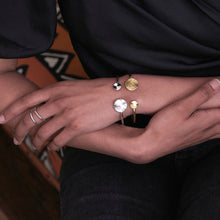 Load image into Gallery viewer, Styled image of model wearing the gold and silver Solaris Cuffs.
