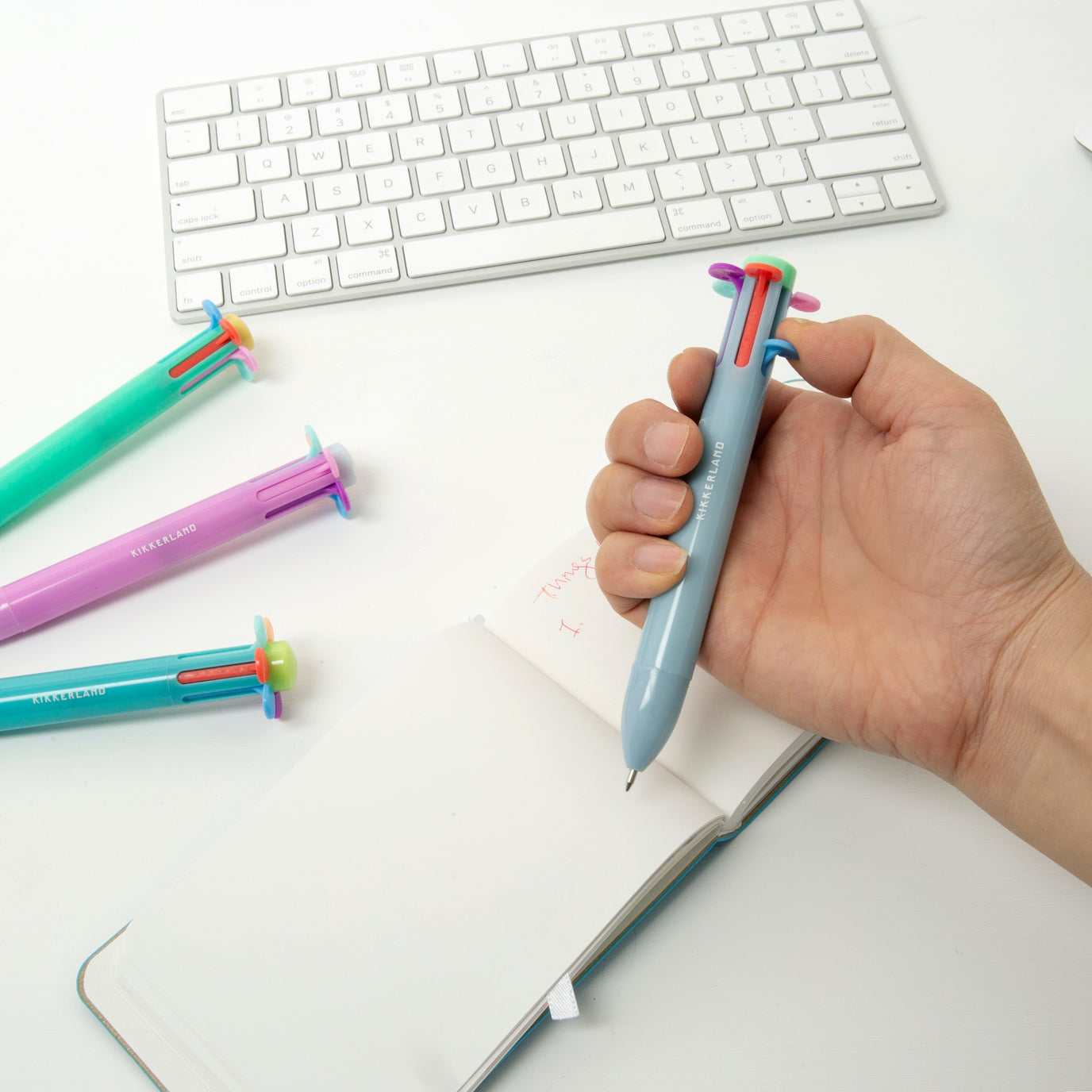 Image of a model using the Rainbow Flower Pen, with a notebook.