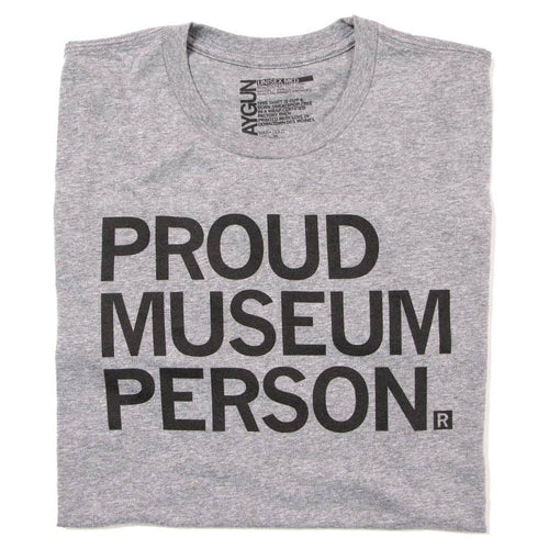 Grey folded tshirt, reading “PROUD MUSEUM PERSON” in black font.