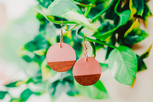 Photo of the “Ava Earring” by jewelry brand Wooden Element, with the earrings hanging on plant.