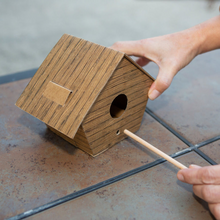 Load image into Gallery viewer, Photo of a model finishing building the DIY Log Cabin Bird House.

