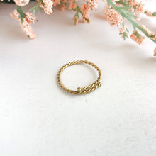 Load image into Gallery viewer, Photo of the gold Twisted Stacking Ring, next to flowers.
