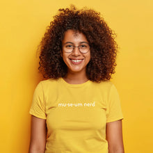 Load image into Gallery viewer, Model wearing Museum Nerd 2.0 shirt in front of yellow background.
