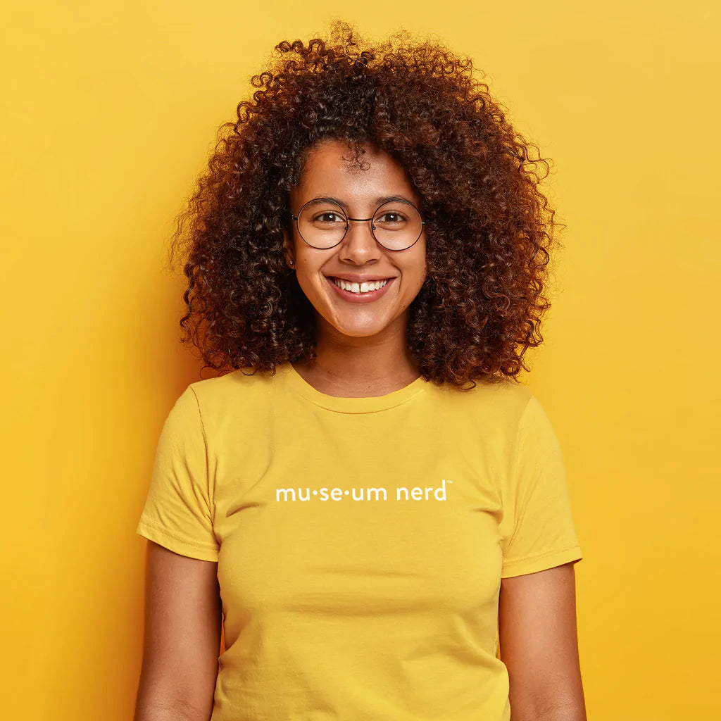 Model wearing Museum Nerd 2.0 shirt in front of yellow background.