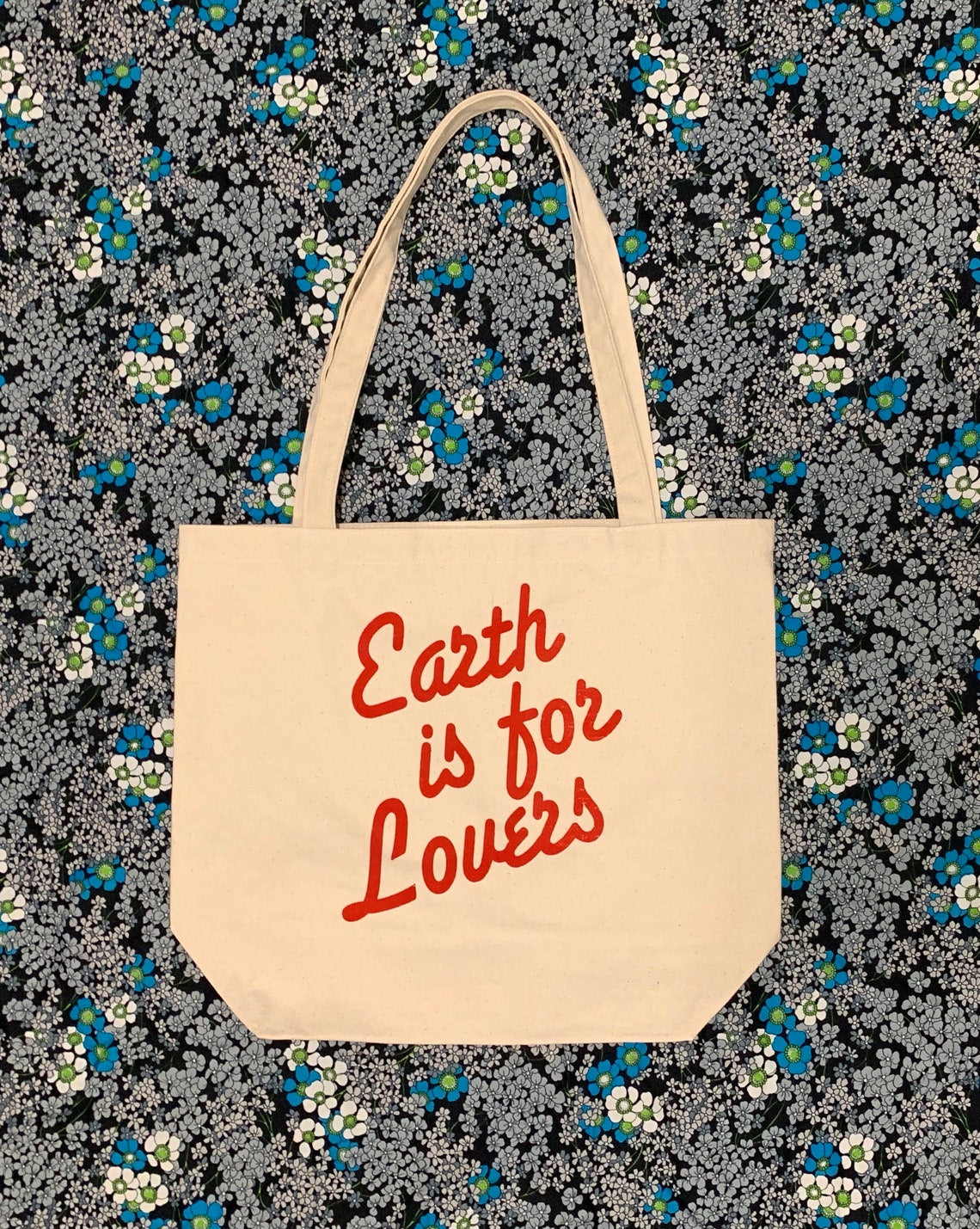 Stock image of “Earth is for Lovers” canvas tote bag.