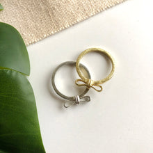 Load image into Gallery viewer, Image of the gold and silver “Wrapped Bow” Rings, next to each other.
