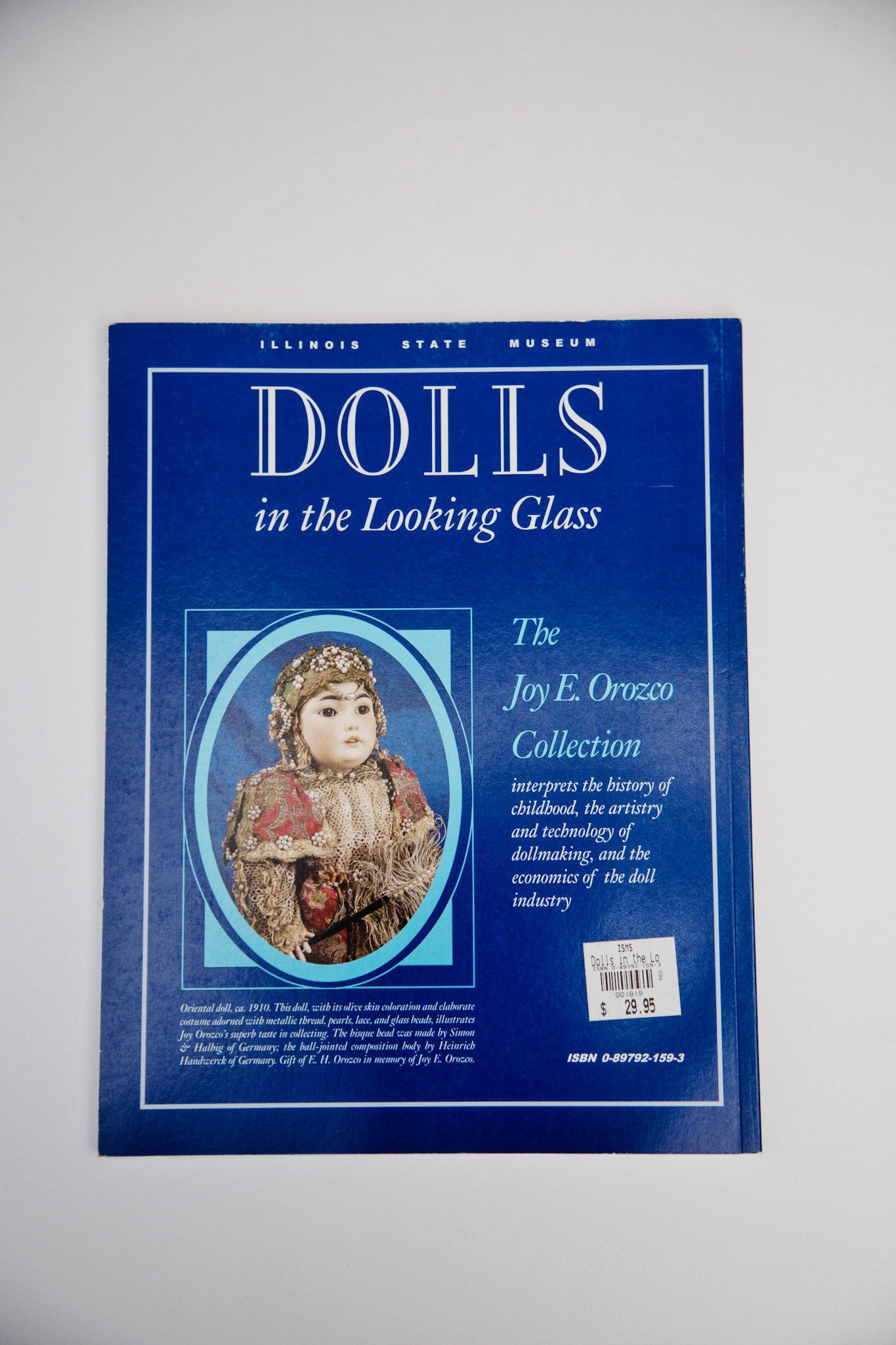 Photo of the back cover of the book “Dolls in the Looking Glass”