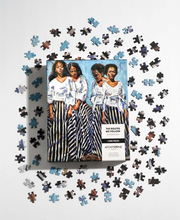 Load image into Gallery viewer, Photo of “The Routes We Follow” puzzle, in its packaging, next to sample puzzle pieces.
