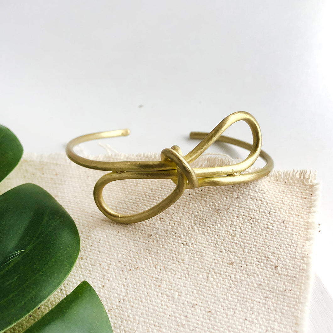 Photo of the gold “Sculptural Bow” Cuff.
