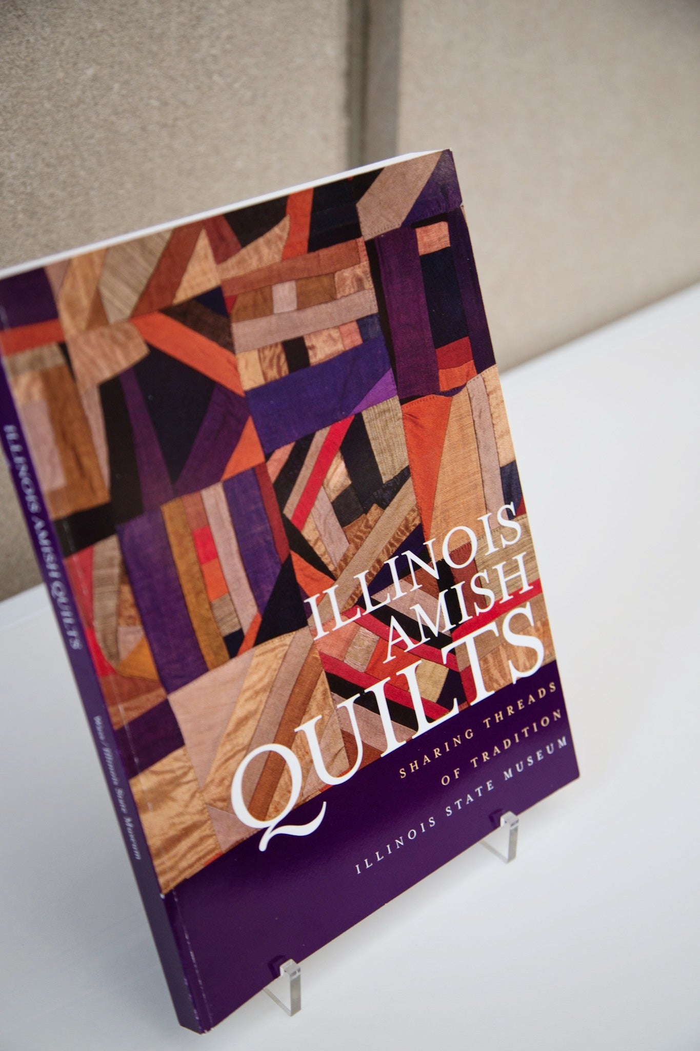 The cover photo for the soft bound “Illinois Amish Quilts: Sharing Threads of Tradition”.
