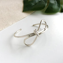 Load image into Gallery viewer, Product photo for the silver “Sculptural Bow” Cuff.
