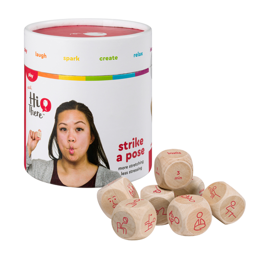 Photo of the “Strike A Pose” Yoga Dice, next to its packaging, on a white background.